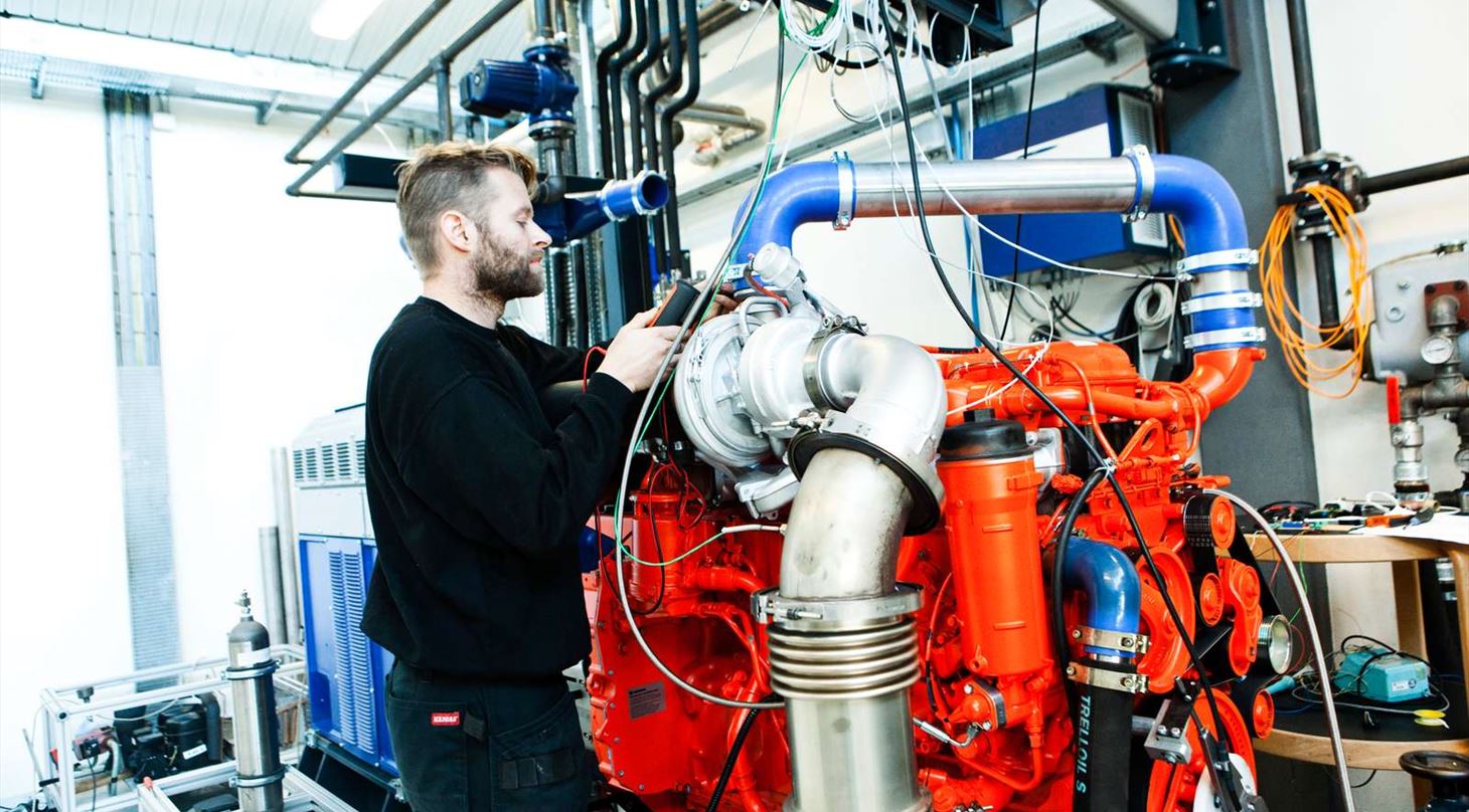 Ekspert som arbejder med motorer i et motorlaboratorium p� Teknologisk Institut.